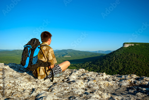 Young man with backpack sits