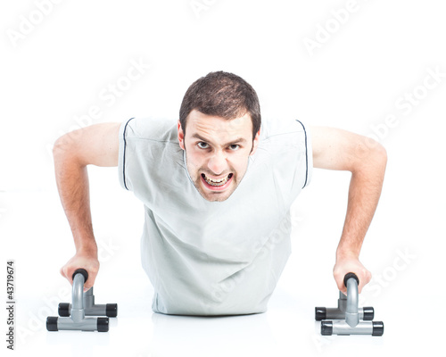 Young guy doing push ups isolated on white background
