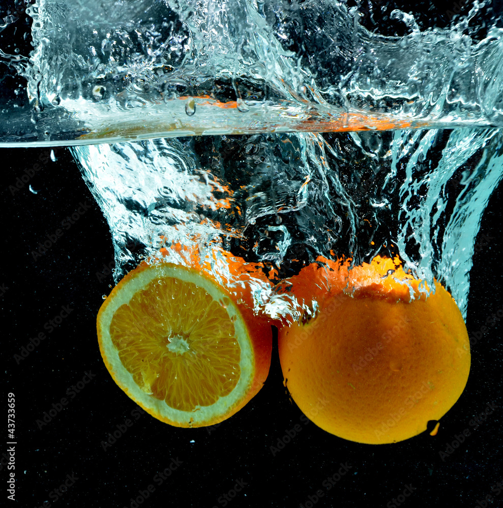 Naklejka premium Pomarańczowy owoc Splash na wodzie