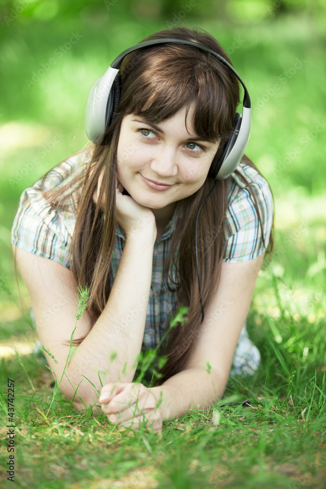 Young fashion girl with headphones at green spring grass. Young fashion girl with headphones at green spring grass.