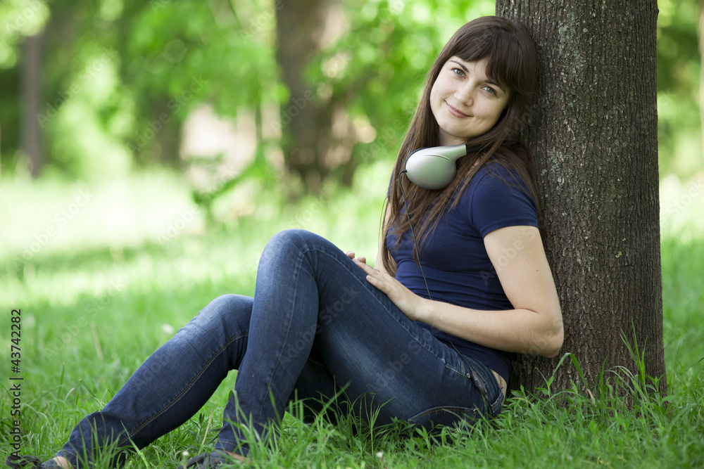 Young fashion girl with headphones at green spring grass. Young fashion girl with headphones at green spring grass.