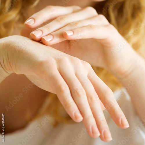 Closeup of woman hands applying cream