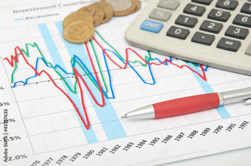 Calculator, coins and pen laying on chart Calculator, coins and pen laying on chart