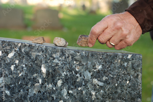 Placing stone on tombstone