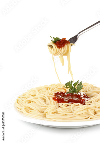 Italian spagetti cooked in a white plate with fork