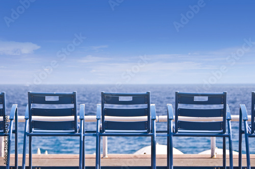 Foto Chaises  métalliques bleues rétro sur la Promenade des Anglais, vue sur la plage