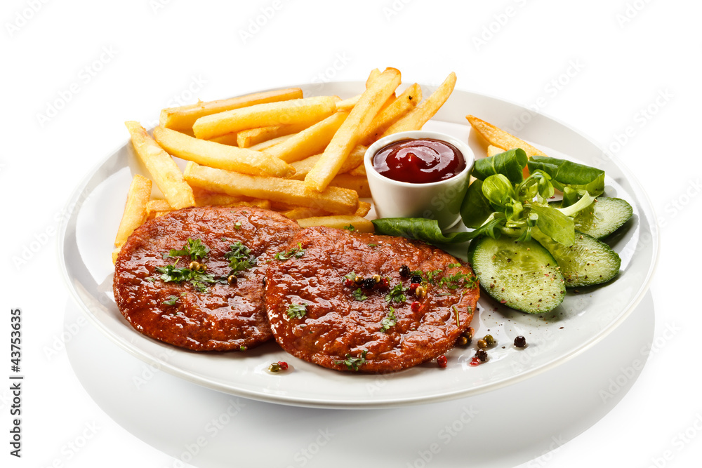 Grilled steaks, French fries and vegetables Grilled steaks, French fries and vegetables