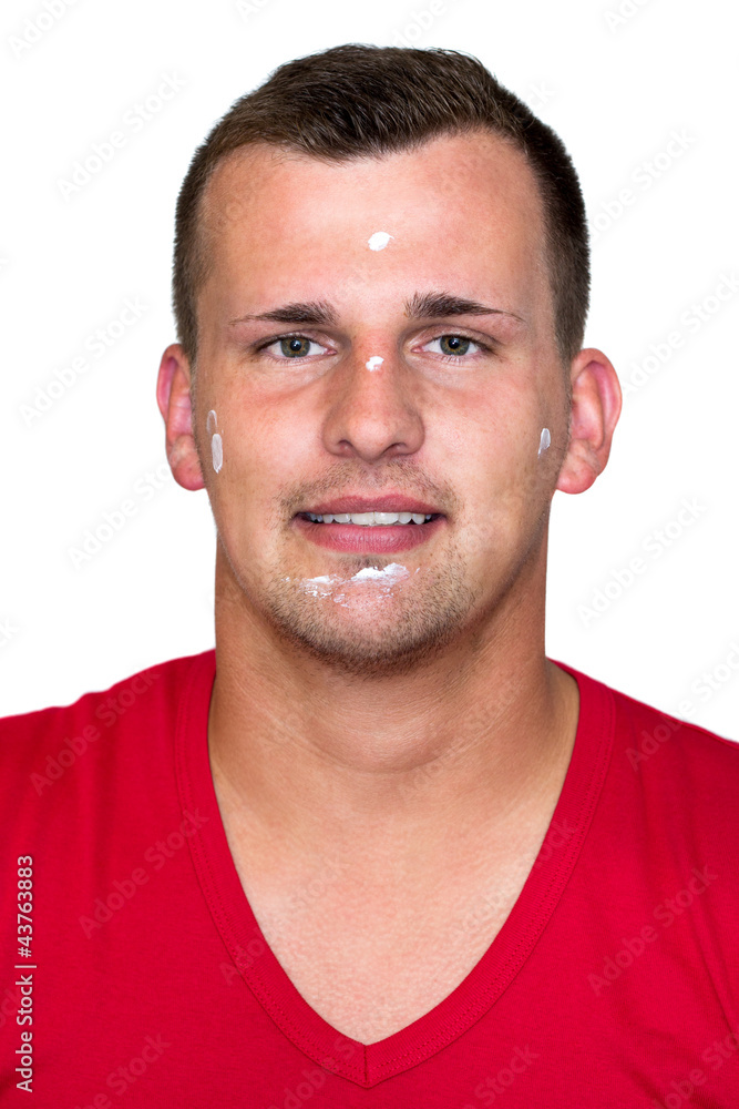 Fototapeta premium Young white man with moisturizer cream in his face