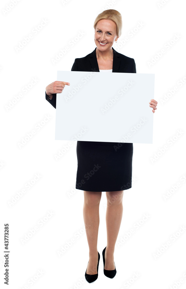 Female executive pointing towards white ad board Female executive pointing towards white ad board
