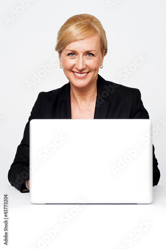 Aged corporate lady working on a laptop