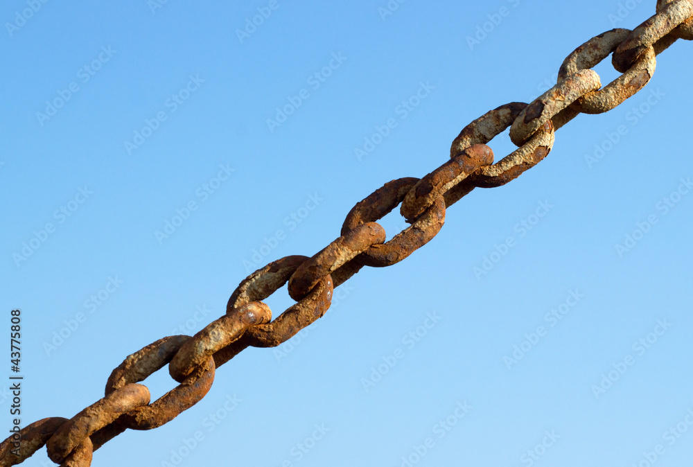 Old rusty metal chain links and a blue sky. Old rusty metal chain links and a blue sky.