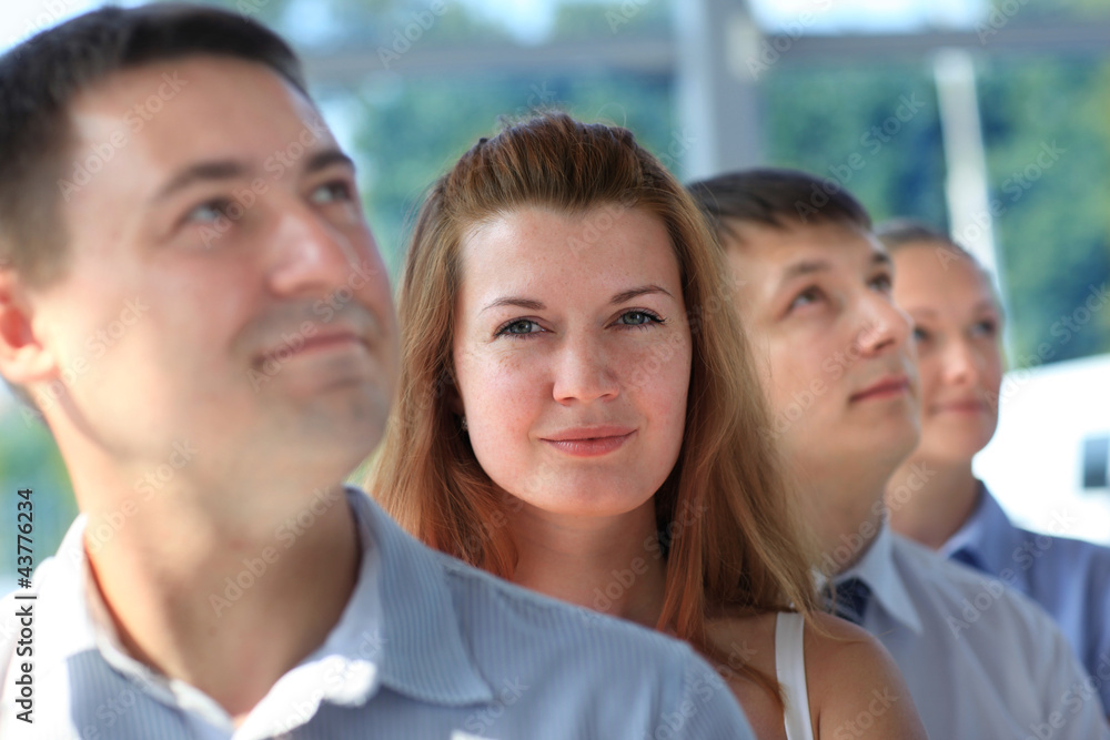 Happy smiling business team standing in a row at office