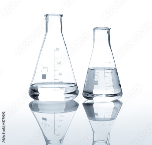 Two laboratory flasks with a clear liquid, isolated