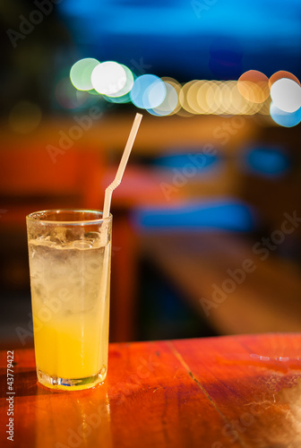 Orange juice on table wilth color of light photo