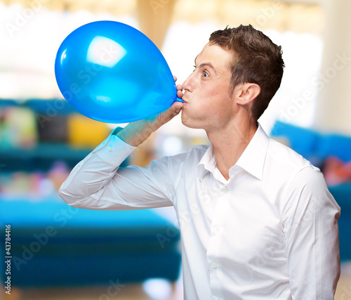 Portrait Of Young Man Blowing A Balloon