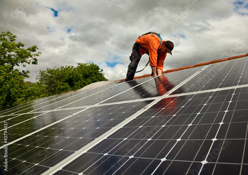 Electrician checking solar panels on roof