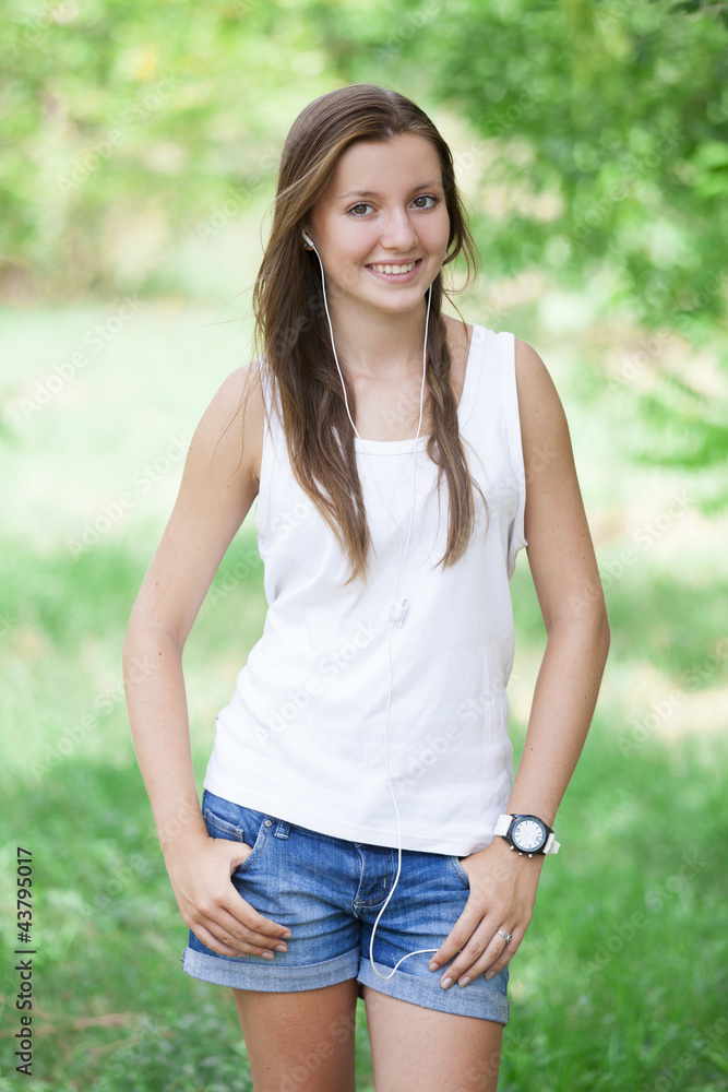 Beautiful teen girl in the park with headphones. Beautiful teen girl in the park with headphones.