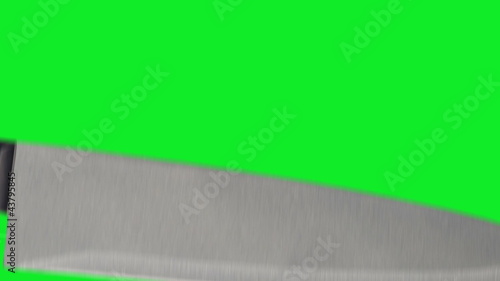 Knife stabbing at item of screen on green screen.