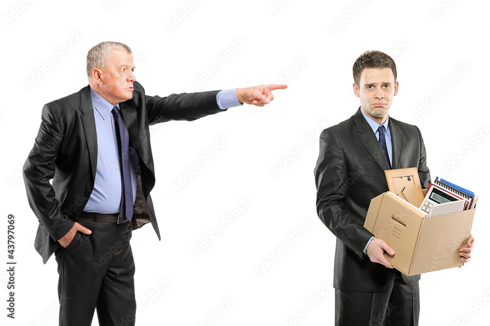Angry boss firing a man carrying a box of personal items Angry boss firing a man carrying a box of personal items