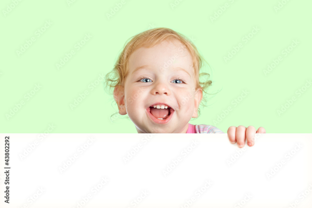 Happy child face behind blank advertising banner. Banner and gre Happy child face behind blank advertising banner. Banner and gre