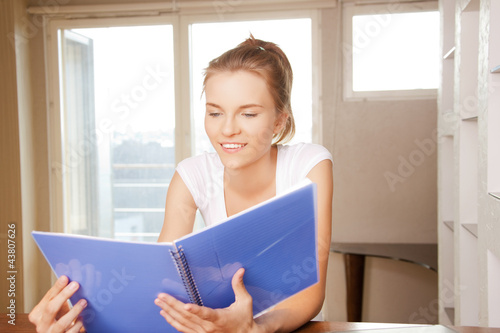 happy and smiling teenage girl with big notepad