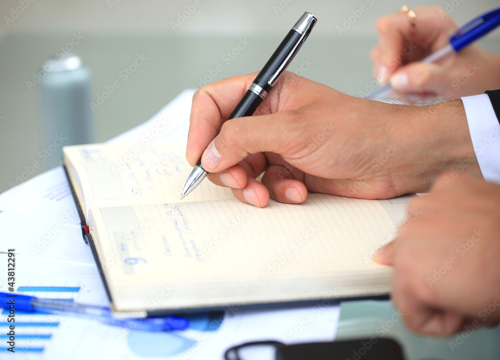 Hands writing on a paper Hands writing on a paper