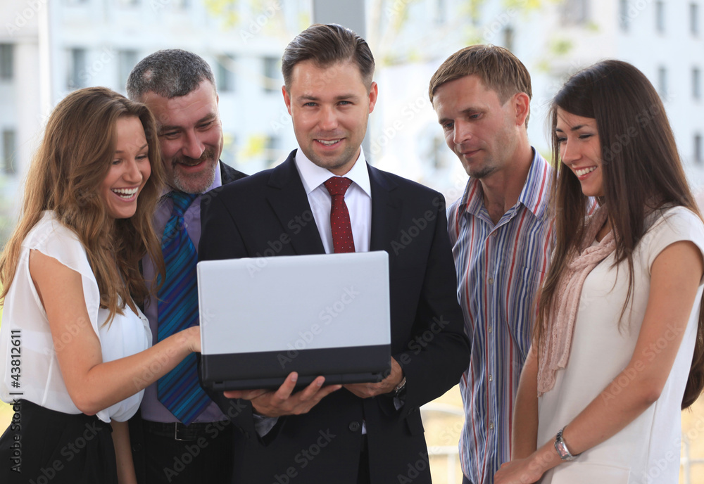 business team discussing while looking at laptop together business team discussing while looking at laptop together