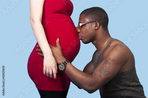 black man kissing his white pregnant