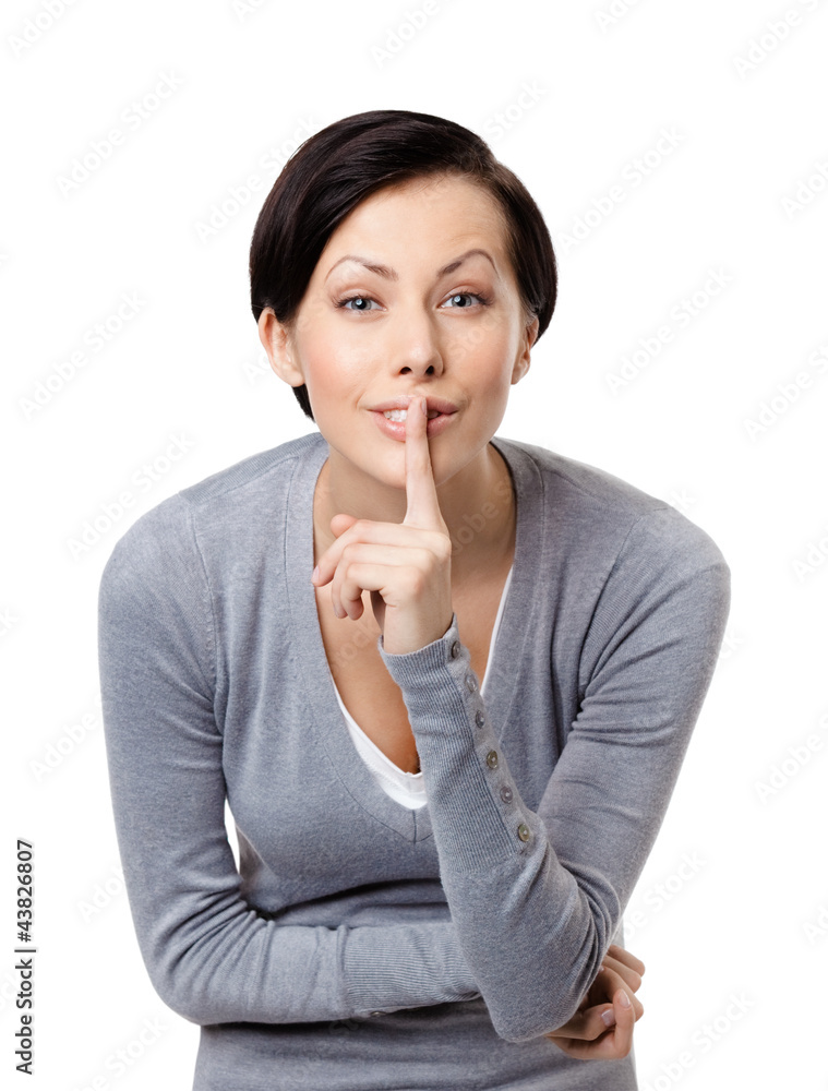 Woman shows silence gesture touching her lips, isolated on white Woman shows silence gesture touching her lips, isolated on white