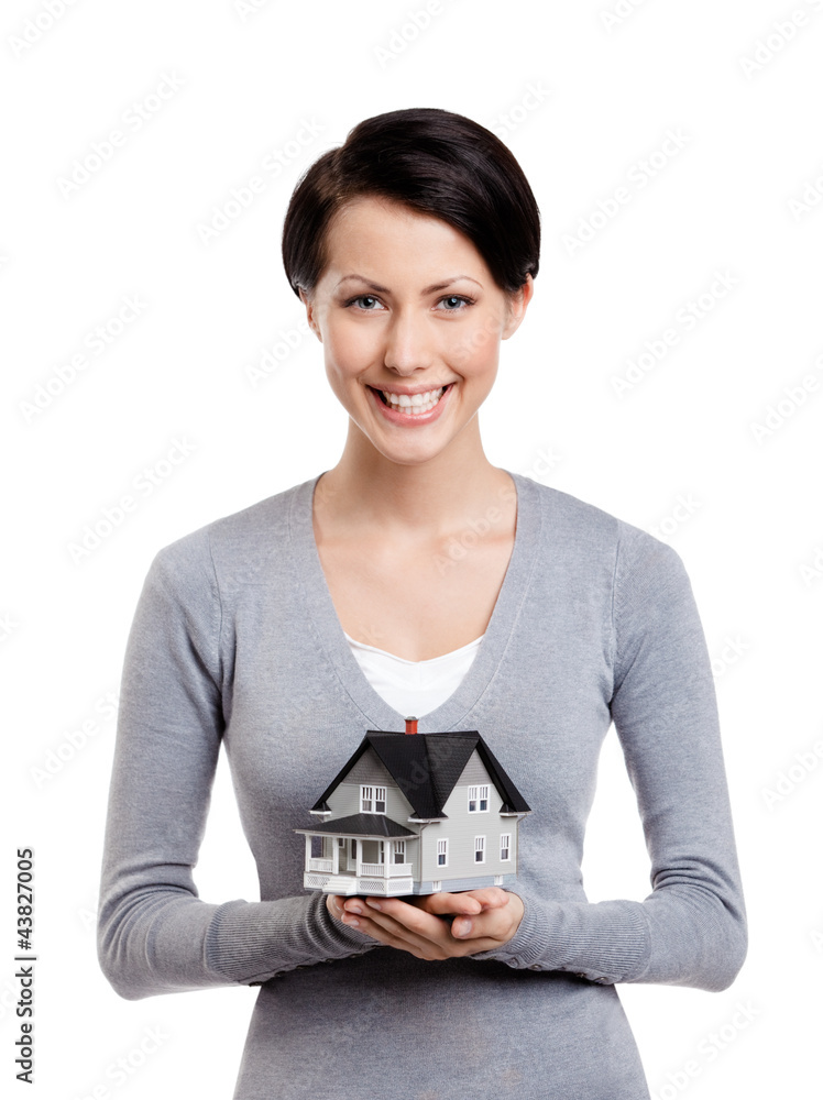 Woman hands small toy house in front of herself, isolated Woman hands small toy house in front of herself, isolated