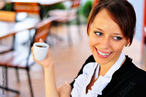 Smiley woman holding a cup of coffee in a hand