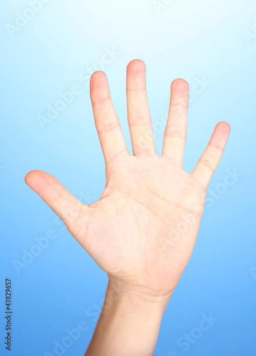 Hand making sign on blue background