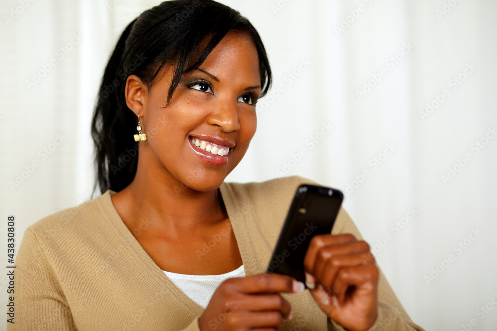 Smiling female sending a message by the cellphone Smiling female sending a message by the cellphone