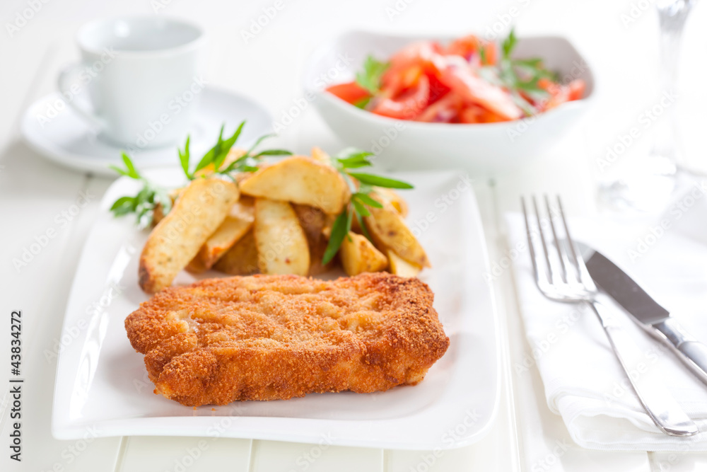 Schnitzel with wedges and tomato salad Schnitzel with wedges and tomato salad