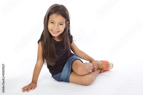 Foto enfant assise souriante sur fond blanc