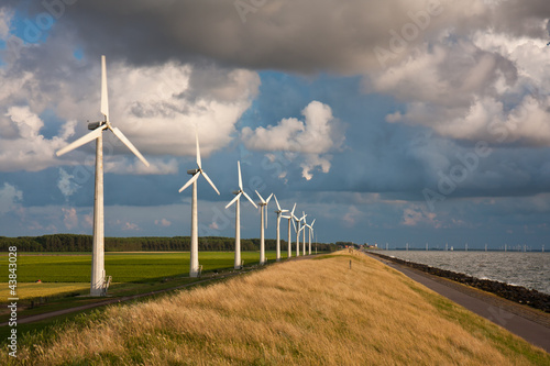 Dutch Windturbines and a cloudscape in the last sunlight of a su