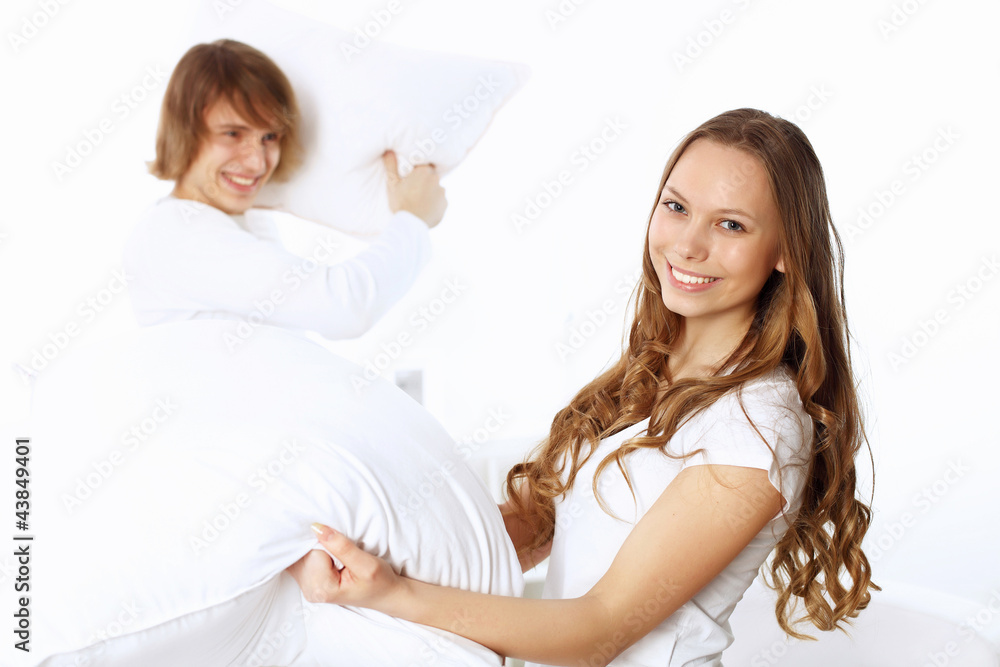 Young couple fighting with pillows