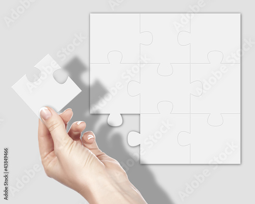 Puzzle pieces and human hand