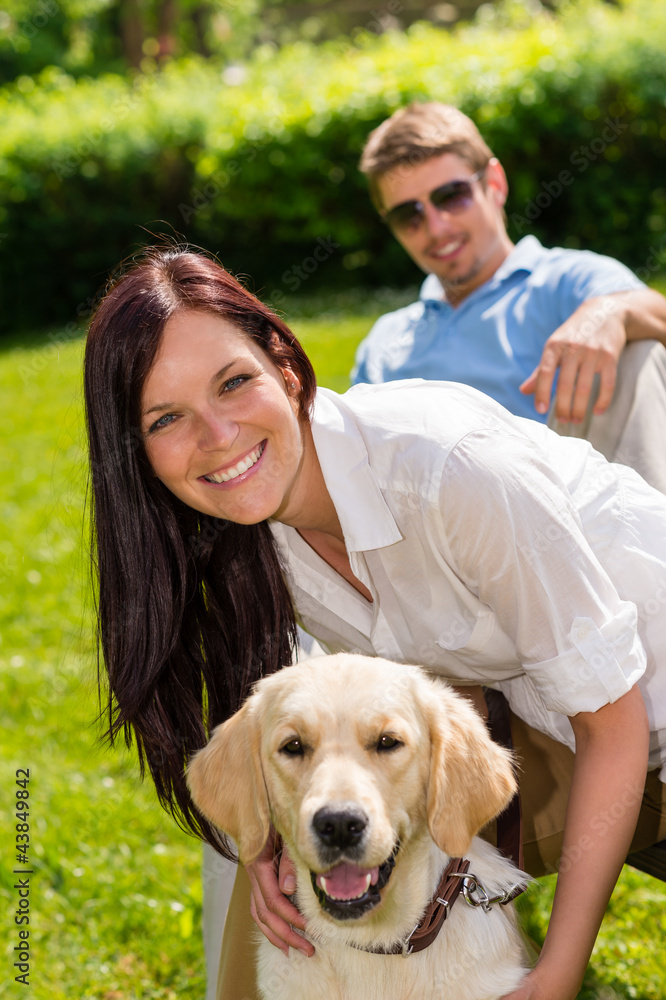 Couple sitting with golden retriever in park Couple sitting with golden retriever in park