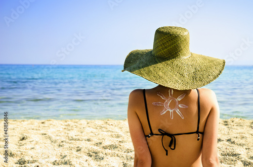 Woman on beach with sun symbol on her back