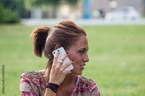 Beautiful smiling girl, talking with her smartphone