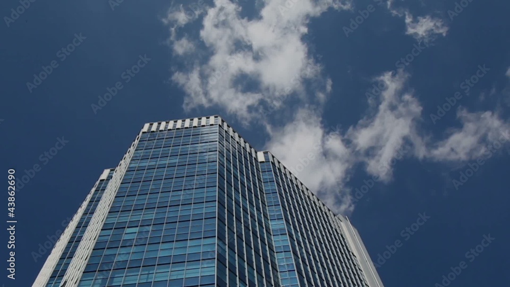 Skyscraper on sky background. Look up. Time lapse. Skyscraper on sky background. Look up. Time lapse.