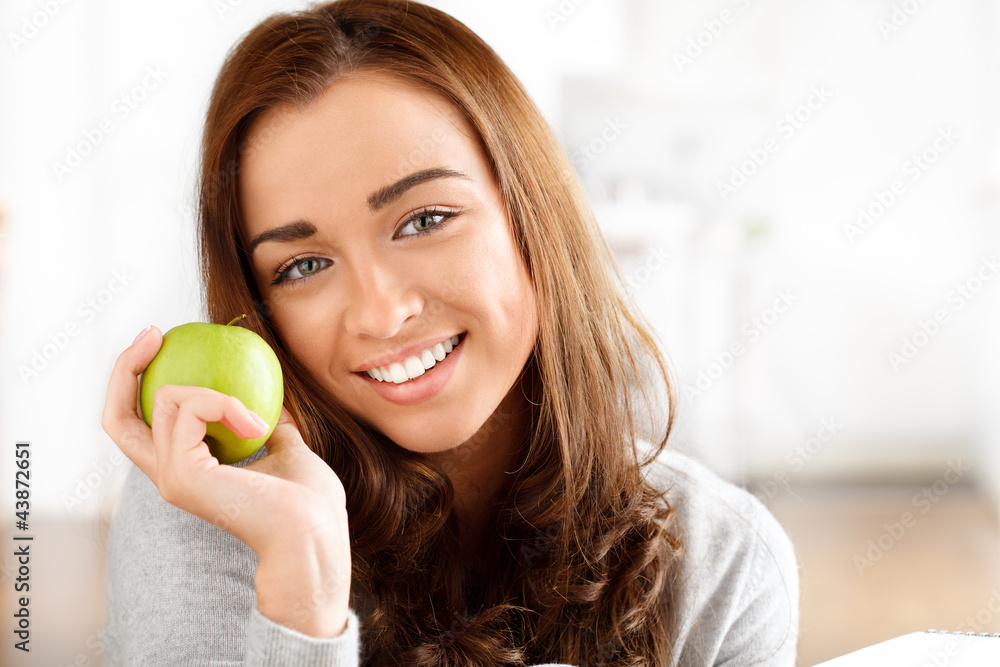 Pretty healthy young woman smiling holding a green apple Pretty healthy young woman smiling holding a green apple