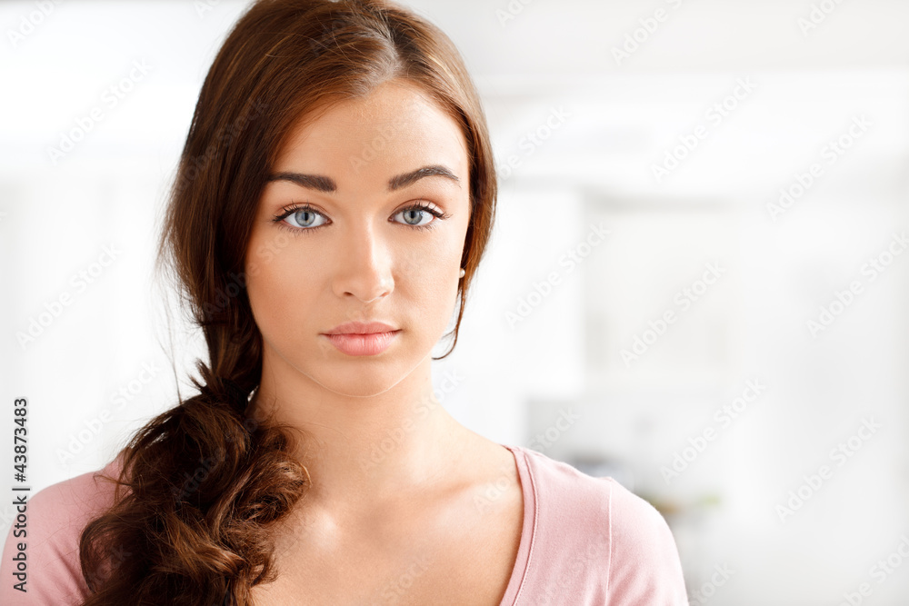 Close-up portrait of an attractive young woman smiling staring a Close-up portrait of an attractive young woman smiling staring a