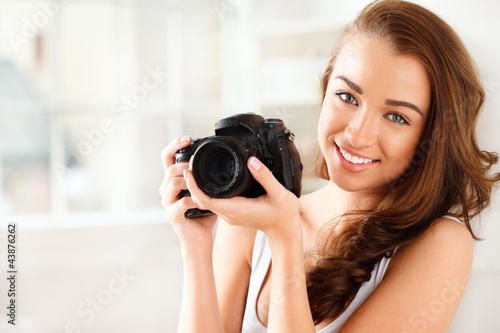 Pretty woman is a proffessional photographer with dslr camera
