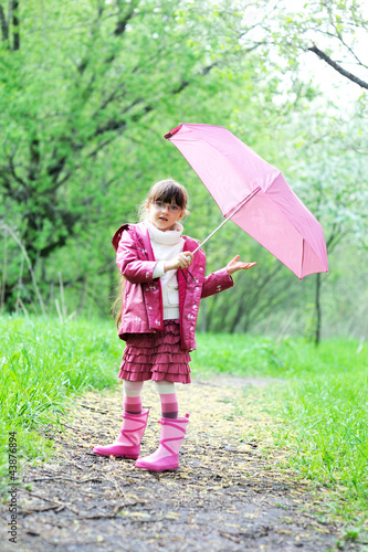 Kid girl posing outdoors with pink umbrella