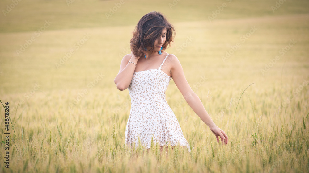 Young beautiful woman in a wheat field with white dress. Young beautiful woman in a wheat field with white dress.
