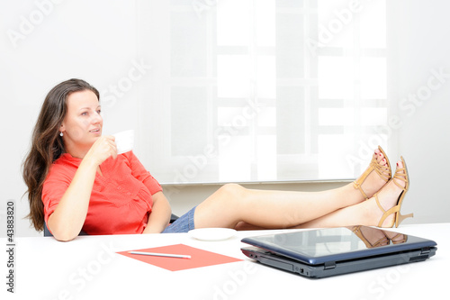 Businesswoman having a coffee break in her office photo