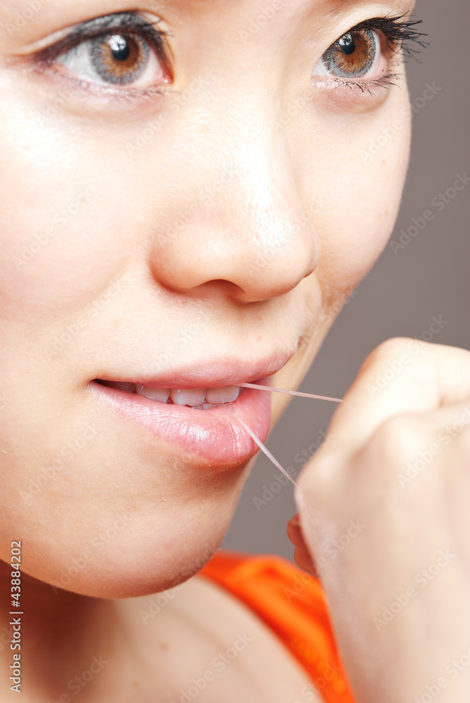 Obraz premium Portrait of a beautiful caucasian woman using dental floss