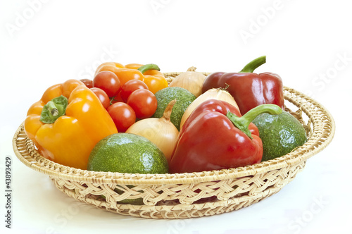 Fresh vegetables in a basket on white background